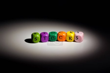 Close up view of stocks text on colorful wooden blocks under focus light, business concept.