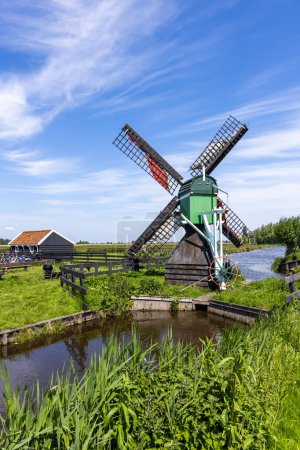 Photo for Small historic Dutch style windmill in Zaanse Schans, The Netherlands against blue sky. - Royalty Free Image