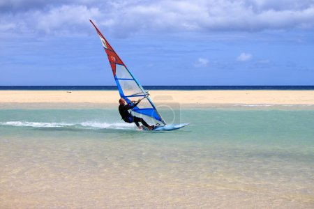 Foto de Costa Calma, España - 13 de mayo de 2022: Surfista en Playa Sotavento en Fuerteventura. Islas Canarias, España - Imagen libre de derechos
