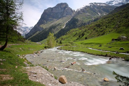 Photo for The mountain stream Doron de Chaviere, located along the Chaviere valley above Pralognan la Vanoise, gateway to the Vanoise National Park, Northern French Alps, Tarentaise, Savoie, France, with the hamlet Les Prioux in the background - Royalty Free Image