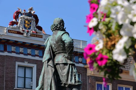 Foto de Primer plano de la estatua de Jan Pieterszoon Coen (1587, 1629) situada en Roode Steen Square en Hoorn, Frisia Occidental, Países Bajos, con fachadas históricas en el fondo. La estatua fue inaugurada en 1893. - Imagen libre de derechos
