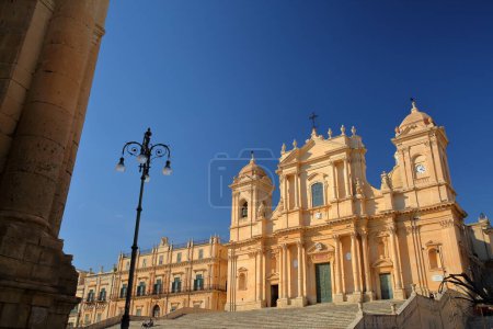Basilica Minore di San Nicolo (Cathedral of St Nicholas), located on Piazza del Duomo (Duomo Square) in Noto, Syracuse, Sicily, Italy, with the town hall (Ducezio Palace) in the foreground on the left