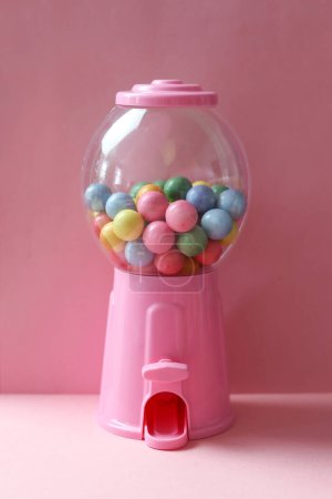 Photo for Colorful gum balls in a plasticvending machine with pink background. - Royalty Free Image
