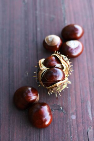 Photo for Shiny fresh chestnuts on a wooden background - Royalty Free Image