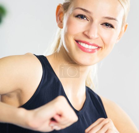 Photo for Young woman in sports wear doing fitness exercise, indoors - Royalty Free Image