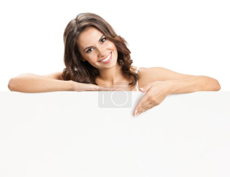 Téléchargez les photos : Joyeux sourire belle jeune femme montrant panneau vierge ou copyspace pour slogan ou texte, isolé sur fond blanc - en image libre de droit