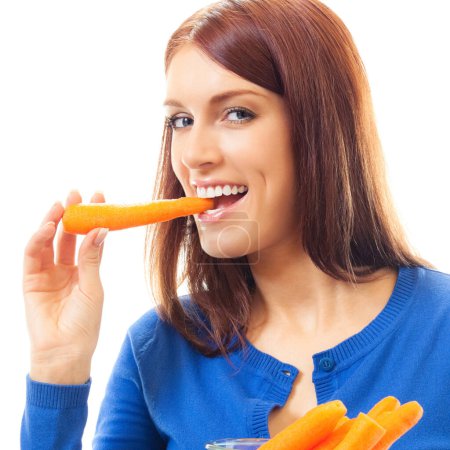 Téléchargez les photos : Portrait de femme joyeuse mangeant des carottes, isolée sur fond blanc - en image libre de droit