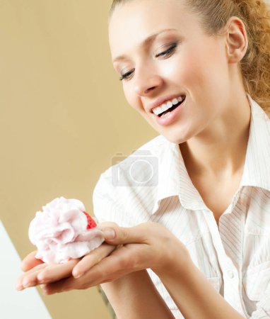 Téléchargez les photos : Joyeux sourire femme blonde manger gâteau, à la maison - en image libre de droit