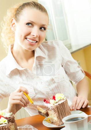 Foto de Joven rubia alegre comiendo torta, en el interior - Imagen libre de derechos