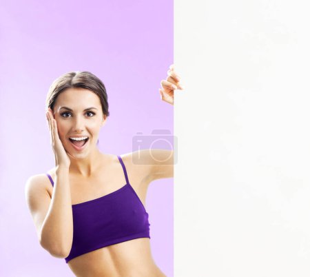 Téléchargez les photos : Joyeux jeune femme en tenue de fitness montrant panneau vierge ou copyspace, sur fond rose - en image libre de droit