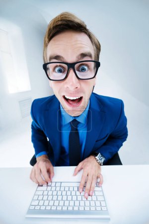 Photo for Very happy or surprised businessman in blue suit and glasses, working with computer at office. Success in business, job and education concept. - Royalty Free Image