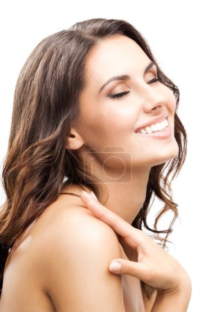 Téléchargez les photos : Portrait de belle jeune femme souriante heureuse touchant la peau ou appliquant de la crème, isolée sur fond blanc - en image libre de droit