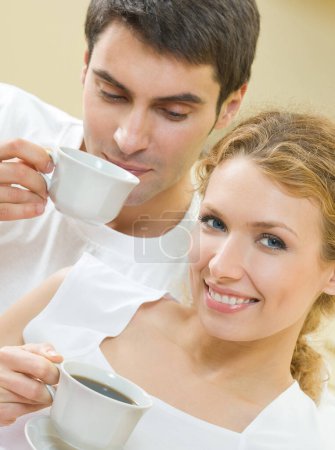 Téléchargez les photos : Couple joyeux avec des tasses de café, intérieur - en image libre de droit