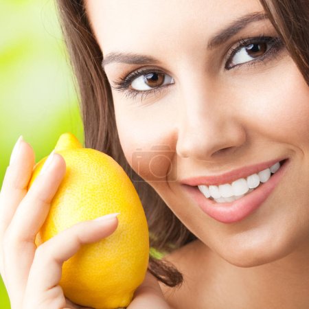 Photo for Young happy smiling woman with lemon, outdoors - Royalty Free Image