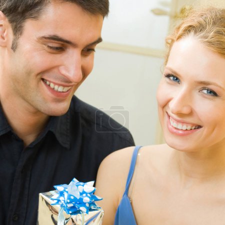 Photo for Cheerful amorous couple with gifts, indoors - Royalty Free Image