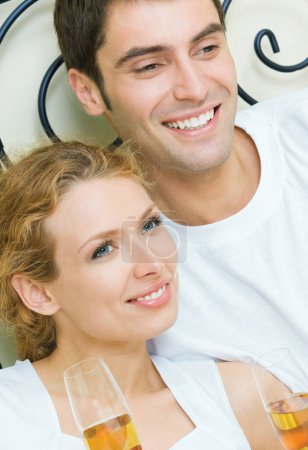 Foto de Retrato de alegre pareja sonriente con champán, interior - Imagen libre de derechos