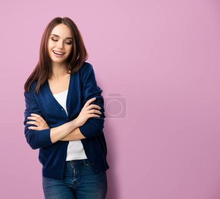 Photo for Portrait of young smiling woman in casual smart blue clothing with crossed arms, over pink background, with copyspace for slogan or text message - Royalty Free Image