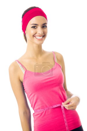 Photo for Woman in red sportswear measuring waist with a tape measure, isolated - Royalty Free Image