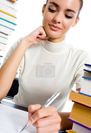Téléchargez les photos : Femme écrivant avec des manuels scolaires, isolée sur fond blanc - en image libre de droit