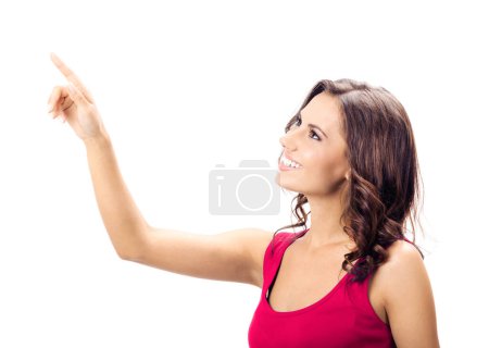 Foto de Vista de perfil de una hermosa mujer joven sonriente con ropa roja elegante casual, mostrando espacio de copia, imaginario visual o algo, o presionando el botón virtual, aislado sobre fondo blanco - Imagen libre de derechos