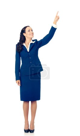 Téléchargez les photos : Corps complet de heureux souriant jeune belle femme d'affaires en costume bleu confiant, apparaissant sur quelque chose ou zone de copyspace pour le produit ou le texte de signe, isolé sur fond blanc - en image libre de droit