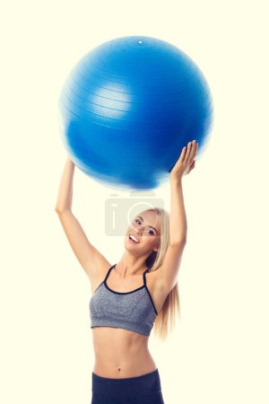 Foto de Joven mujer rubia sonriente alegre en ropa deportiva con fitball, aislada sobre fondo amarillo. Concepto de fitness, ejercicio y fitness. - Imagen libre de derechos