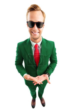 Foto de ¿Y qué? Retrato de cuerpo completo de joven empresario divertido en gafas de sol, traje verde confiado y corbata roja, plano de vista de ángulo superior, aislado sobre fondo blanco. Concepto empresarial. - Imagen libre de derechos