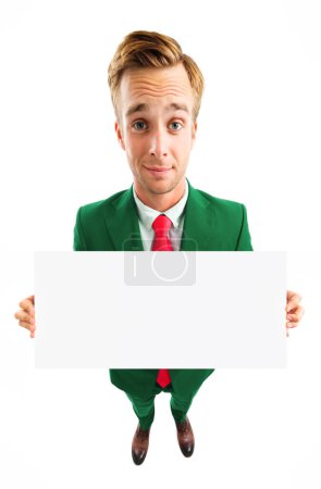 Photo for Full body portrait of funny young businessman in green confident suit and red tie, showing blank signboard with copyspace area for advertising text or slogan, top angle view shot, isolated over white background. Business concept. - Royalty Free Image
