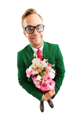 Ganzkörperporträt eines lustigen jungen Geschäftsmannes mit Brille, grünem selbstbewussten Anzug und roter Krawatte, Blumenstrauß in der Hand, Aufnahme aus der Vogelperspektive, isoliert vor weißem Hintergrund. Geschäftskonzept.