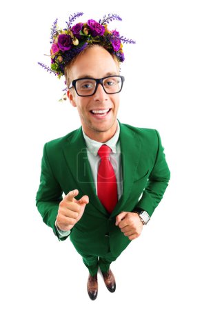 Foto de Retrato de cuerpo completo de divertido hombre de negocios feliz en gafas, traje verde confiado, corbata roja y corona de flores silvestres en su cabeza, apuntando hacia ti, plano de vista de ángulo superior, aislado sobre fondo blanco. - Imagen libre de derechos