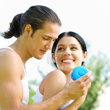 Photo for Cheerful young smiling couple with dumbbells on outdoor fitness workout - Royalty Free Image