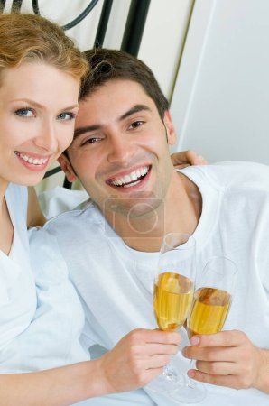 Téléchargez les photos : Portrait de couple souriant joyeux avec champagne, à l'intérieur - en image libre de droit