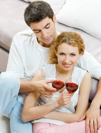 Foto de Retrato de alegre pareja sonriente con copas de vino tinto, en el interior - Imagen libre de derechos