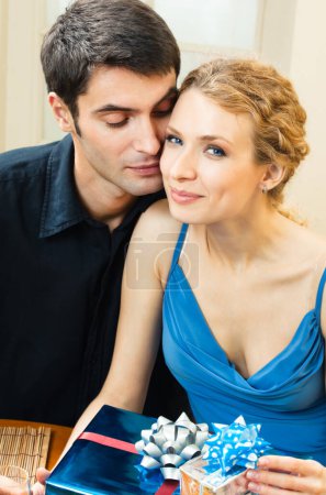 Photo for Cheerful amorous couple with gifts, indoors - Royalty Free Image