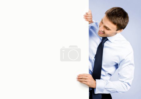 Photo for Portrait of happy smiling young business man showing blank signboard, over violet background - Royalty Free Image