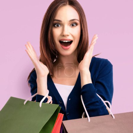 Photo for Very happy beautiful young woman with shopping bags, over purple background - Royalty Free Image