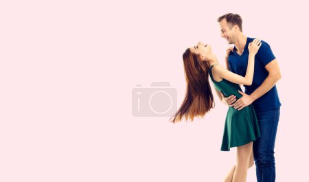 Umarmung oder tanzendes Paar, sich anschauend, mit einem leeren Bereich für Slogans oder Werbetexte, vor rosa Hintergrund. Kaukasische Models in Liebe, Beziehung, Dating, Flirten, Liebende, romantisches Studiokonzept.