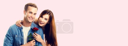Téléchargez les photos : Portrait de jeune couple heureux câlin avec fleur, avec espace de copie vide pour slogan ou message publicitaire, sur fond rose. modèles caucasiens dans l'amour, relation, rencontres, flirt, amoureux, concept romantique. - en image libre de droit
