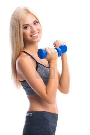 Foto de Joven mujer rubia sonriente feliz en ropa deportiva, haciendo ejercicio de fitness con mancuernas, aislado sobre fondo blanco - Imagen libre de derechos