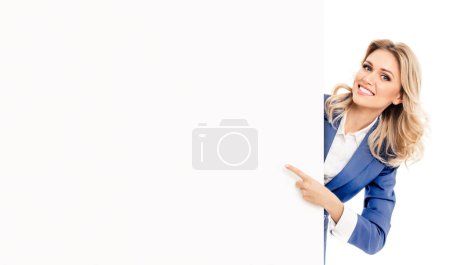 Photo for Happy smiling young businesswoman in blue confident suit, showing blank signboard with copyspace empty area for slogan or advertise text, isolated against white background. Blond model in business success concept. - Royalty Free Image