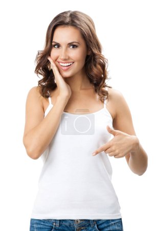 Téléchargez les photos : Joyeux sourire belle jeune femme montrant copyspace pour certains texte, publicité ou slogan, isolé sur fond blanc - en image libre de droit
