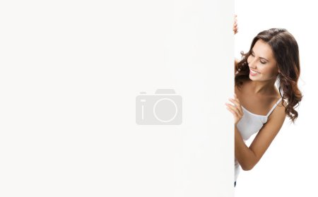 Foto de Feliz sonrisa hermosa joven mostrando letrero en blanco con espacio de copia para algún texto, publicidad o eslogan, aislado sobre fondo blanco - Imagen libre de derechos
