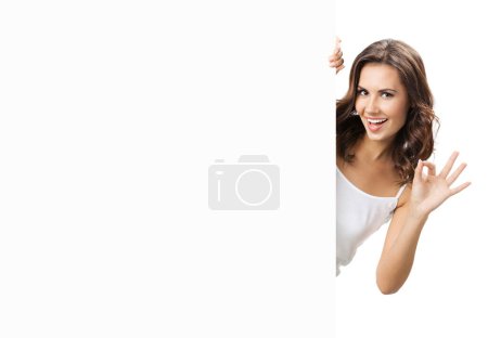 Photo for Happy smiling beautiful young woman showing blank signboard with copyspace for some text, advertising or slogan, isolated against white background - Royalty Free Image
