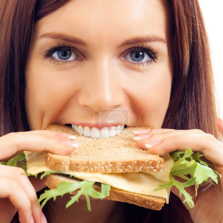 Téléchargez les photos : Joyeux jeune femme mangeant un sandwich au fromage, isolé sur fond blanc - en image libre de droit