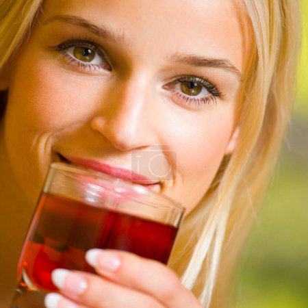 Photo for Portrait of happy smiling blond woman drinking garnet juice - Royalty Free Image