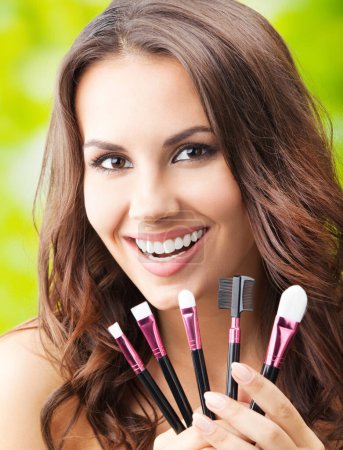Photo for Young happy smiling woman with make up tools - Royalty Free Image