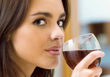 Young happy smiling beautiful woman with glass of red wine