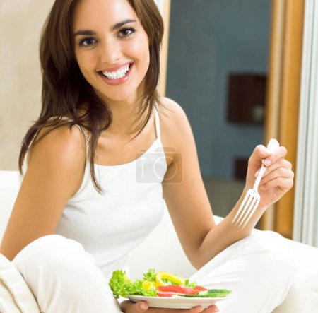 Photo for Beautiful smiling young woman with vegetarian vegetable salad, at home - Royalty Free Image