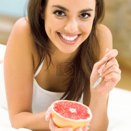 Photo for Portarit of beautiful woman eating grapefruit - Royalty Free Image