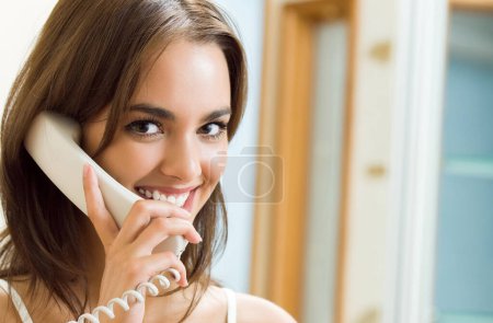 Téléchargez les photos : Belle femme parlant au téléphone, à la maison, avec copyspace - en image libre de droit